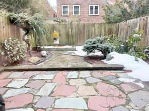 a backyard with a stone walkway and a fence at Cozy Manhattan View Suite in West New York