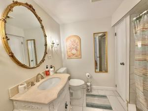 a bathroom with a sink and a toilet and a mirror at Cozy Manhattan View Suite in West New York +12 photos