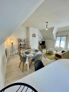 a living room with a table and chairs in a room at Centre Treguier L escapade des quais in Tréguier