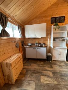 a kitchen in a wooden cabin with a sink at Schwedentraum in Östrahult +13 photos