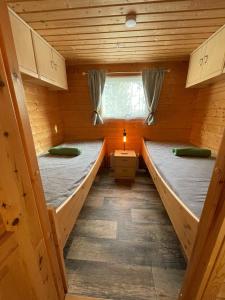a room with two beds in a wooden cabin at Schwedentraum in Östrahult