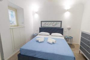 a bedroom with a blue bed with two pillows at LA PERLA in Cefalù