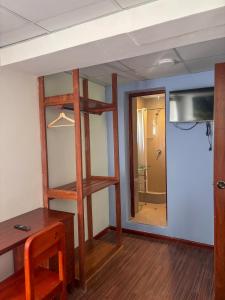 a room with a mirror and a desk and a bathroom at Casona Urinsaya Qolca in Chivay