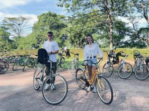 a man and a woman standing next to their bikes at Green Grass Homestay in Sigiriya