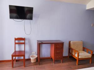 a room with a desk and a chair and a tv at Casona Urinsaya Qolca in Chivay