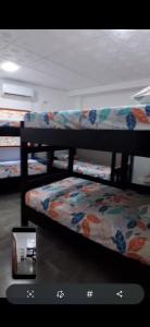 a room with three bunk beds with a couch at Hospedaje Mango y Mar Habitaciones in Coveñas
