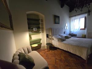 a bedroom with two beds and a couch at Finestra Dell'Angelo in Pienza