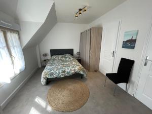 a bedroom with a bed and a large rug at Centre Treguier L escapade des quais in Tréguier