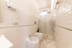 a white bathroom with a toilet and a shower at Riviera Luxury Rooms in Porto Cesareo +31 photos