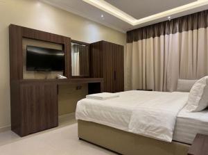 a bedroom with a bed and a flat screen tv at نزل ارام النفل Nozol Aram 4 in Riyadh +27 photos