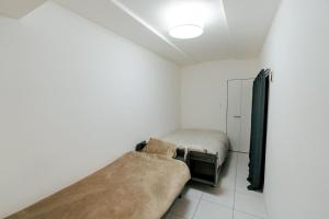 a bedroom with two beds and a couch at マエストラーレ山鼻 in Sapporo