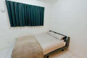 a bed in a room with a green curtain at マエストラーレ山鼻 in Sapporo