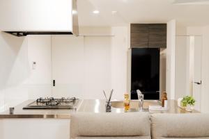 a white kitchen with a sink and a stove at マエストラーレ山鼻 in Sapporo