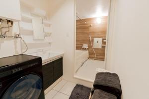 a washing machine in a bathroom with a shower at マエストラーレ山鼻 in Sapporo