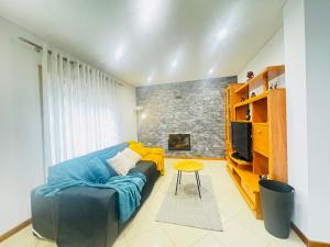 a living room with a blue couch and a tv at Cantinho da Paz in Marinhas