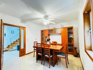 a dining room with a wooden table and chairs at Cantinho da Paz in Marinhas