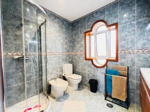 a bathroom with a shower and a toilet and a sink at Cantinho da Paz in Marinhas +14 photos