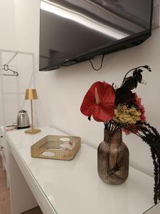 a vase with flowers on a counter in a kitchen at Ursino inn camere e suite in Catania