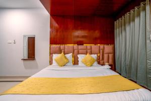 a bedroom with a large bed with yellow pillows at Greenland Premium Hotel in Bhubaneshwar