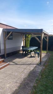a picnic shelter with a picnic table in a yard at Mobilhome à cancale in Cancale