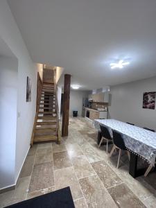 a room with a staircase and a table and chairs at La parenthèse Jurassienne in Orgelet