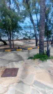 a painting of a beach with a palm tree at Palm breeze seafront shanzu in Shanzu