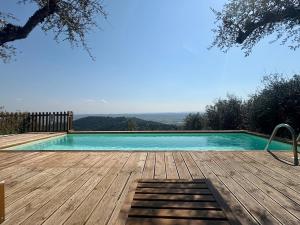 ein Schwimmbecken mit Holzterrasse in der Unterkunft Rivolta home in Buti