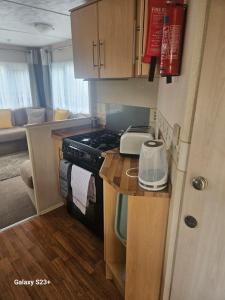a small kitchen with a stove and a counter top at Comforts caravan in Winthorpe