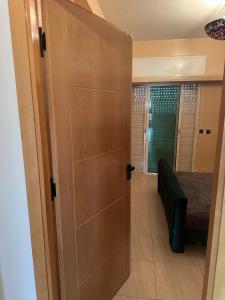 a door leading to a room with a couch and a bed at harhoura Résidence Badia in Temara