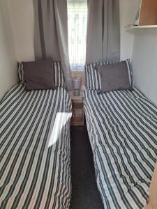 two beds sitting next to each other in a room at Comforts caravan in Winthorpe