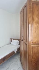 a bedroom with a bed and a wooden cabinet at RESIDENCE Tanta in Douala