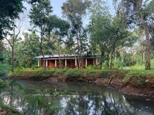 a house in the woods next to a river at Mango Tree Villa in Sigiriya