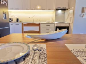a wooden table with a bowl on top of a kitchen at Luce Apartment in Shkodër +14 photos