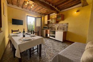 ein Esszimmer mit einem Tisch und einer Küche in der Unterkunft Rivolta home in Buti
