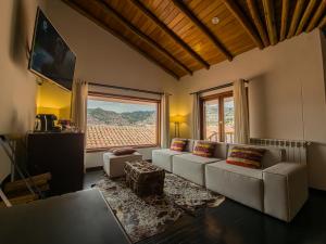 a living room with a couch and a large window at Tocuyeros Boutique Hotel in Cusco