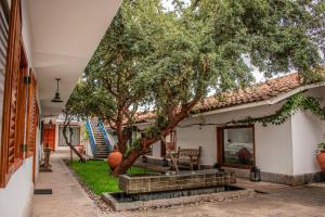a house with a tree in the yard at Tocuyeros Boutique Hotel in Cusco