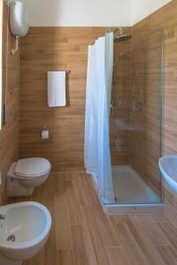 a bathroom with a shower and a toilet and a sink at Le Matine di San Teodoro in Stazione di Metaponto