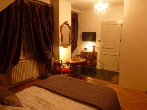 a bedroom with a bed and a table and a chair at Le BALCON DU PRINCE in Montbéliard