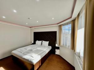 a bedroom with a large bed with a large window at Lotus House in Hermina-major