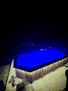 a blue swimming pool at night with a city in the background at B&B IL VOLO in Camaiore