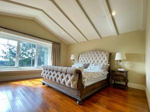 a large bed in a room with a large window at Spacious Cozy House in Vancouver West in Vancouver