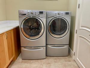 two washing machines sitting next to each other in a kitchen at Spacious Cozy House in Vancouver West in Vancouver