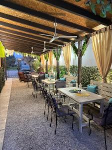 a restaurant with tables and chairs under awning at TEPIĆ Garni Hotel in Temerin