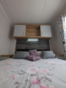 a bedroom with a large bed with pink flowers on it at Swift Bordaux 68 in Ardentinny