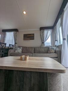 a living room with a couch and a table at Swift Bordaux 68 in Ardentinny