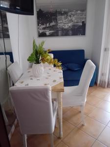 a dining room table with white chairs and a blue couch at Aghi&Salsedine in Anzio +10 photos