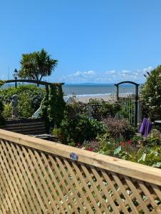 a wooden fence with a view of the beach at Rest Bay Beach Stay in Porthcawl