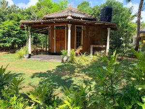 a small building with a porch in a yard at Mango Tree Villa in Sigiriya