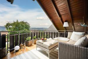 a patio with a couch and a table on a balcony at Fewo Seesternchen in Öhningen