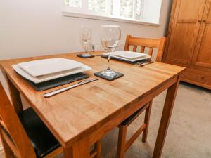 a wooden table with two wine glasses and plates on it at Riber in Matlock +9 photos